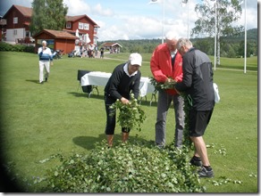 Berit Widholm, Mats Nygårds och Anders Johansson tvinnar ihop björkrumpan